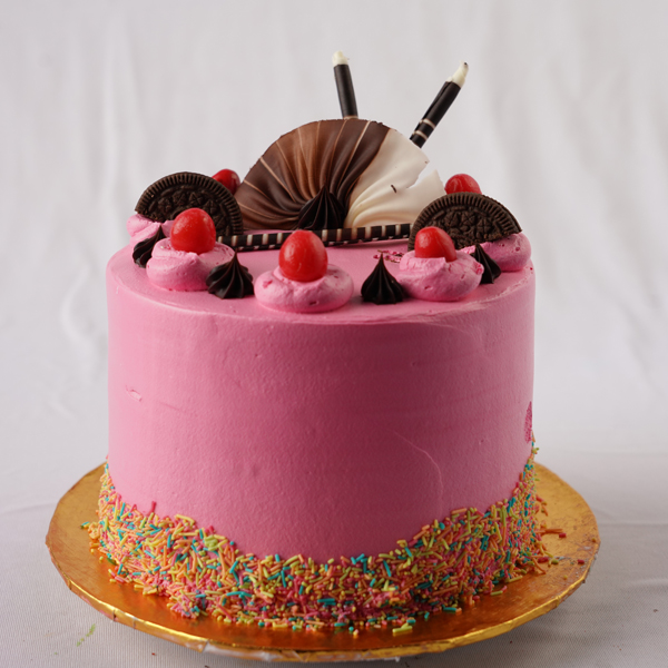 A pink cool cake with cherries and biscuits